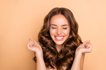 Close-up portrait of nice attractive lovely gorgeous girlish excited cheerful cheery, dreamy lucky wavy-haired girl enjoying expecting pleasure isolated on beige pastel color background